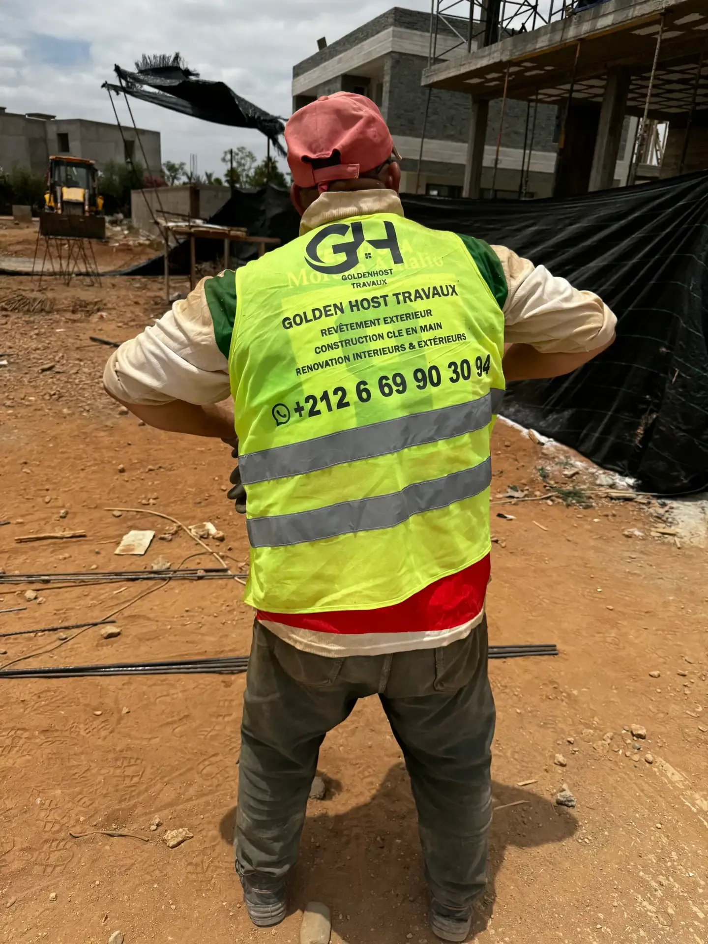 Ouvrier de l'équipe GH Travaux portant un gilet floqué Golden Host Travaux sur un chantier à Marrakech